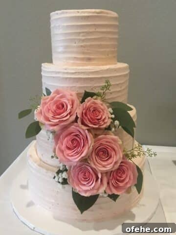 strawberry wedding cake with three layers and pink roses.
